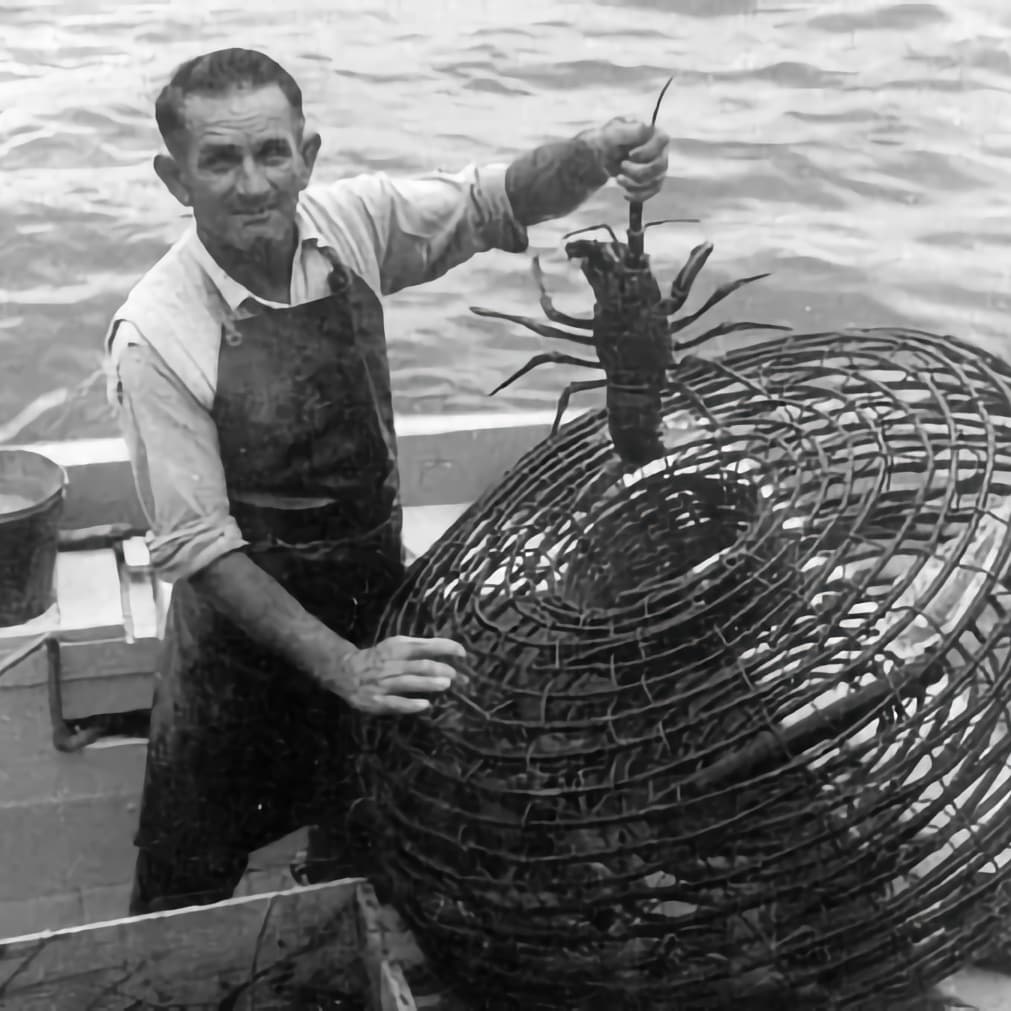 picture in black and white of a cray fisherman with a beehive craypot - this is an old photograph